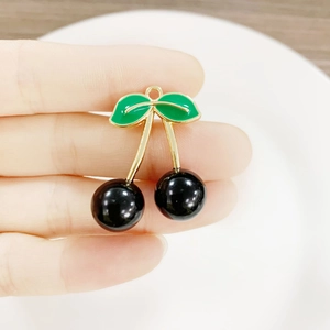 DIY cherry pendant with black fruit and green leaves in golden metal for jewelry making