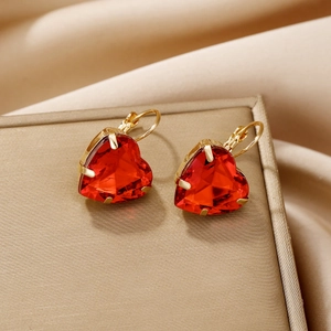 Gros plan de boucles d'oreilles cœurs en cristal rouge facetté et crochets dorés