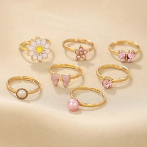 Set of 7 gold adjustable rings for girls featuring daisy, bow, and star charms