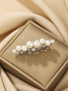 Elegant silver hair clip with gradient pearls and rhinestones on champagne satin fabric