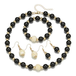 Detail view of black beaded jewelry set including necklace and bracelet with gold accents