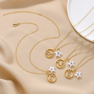 Gold zodiac pendant necklace with sparkling crystal charms and white enamel star accents