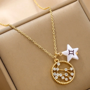 Macro view of gold chain necklace with white star pendant and crystal zodiac disk