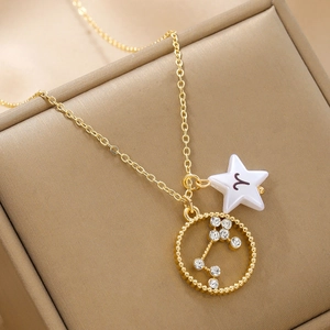 Macro detail of Aries zodiac gold necklace with star pendant and crystal circle