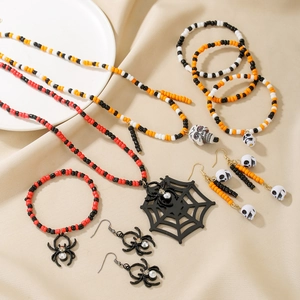 Detailed set of Halloween beaded jewelry with spider webs and skull charms on velvet