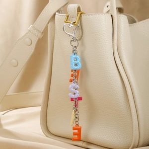 Porte-clés alphabet coloré en strass avec fermoir cœur sur un sac en cuir