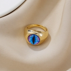Detailansicht des goldenen Evil-Eye-Rings auf Seidenstoff mit blau-violettem Iris-Muster