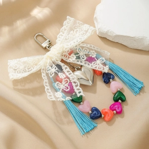 Détail du nœud en dentelle blanche et pendentif cœur avec perles colorées en forme de cœur