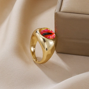 Detail eines Gold-Punk-Rings mit gelbem bösen Auge auf braunem Satinstoffhintergrund
