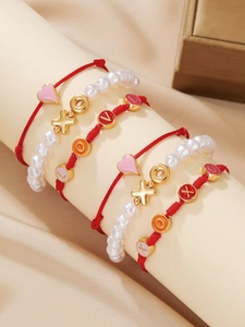 Detail von Armband-Set aus rotem Seil und Perlen mit goldenen Herz-Anhängern