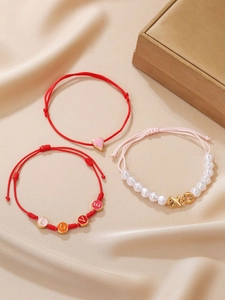 Dreiteiliges Armband-Set mit LOVE und XOXO Perlen auf Seidenhintergrund