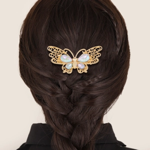 Peigne à cheveux papillon doré serti de cristaux sur une coiffure avec tresse