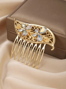 Gros plan d'un peigne à cheveux doré à motif de feuille creuse et strass irisés