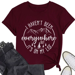 Detail eines weinroten Baumwoll-T-Shirts mit weißem Bergprint und Reisespruch