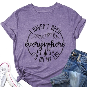 Lila T-Shirt mit Berggrafik und Spruch kombiniert mit Jeans und weißen Segeltuchschuhen