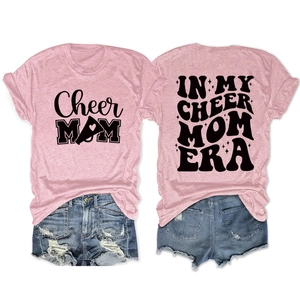 Flat lay of pink Cheer Mom t-shirt and denim shorts showing front and back print design