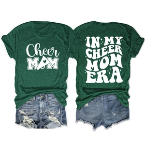 Detail of double-sided print on heather green Cheer Mom T-shirt and denim shorts