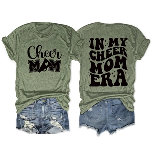 Detailed front and back view of green Cheer Mom Era printed t-shirt with denim shorts