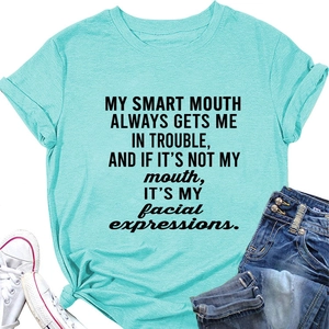Detail of light blue cotton T-shirt featuring black lettering and a side-knot hem detail