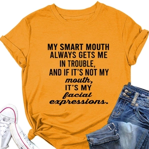 Detail of mustard orange T-shirt featuring a knot hem and bold slogan text print