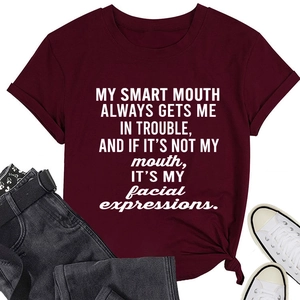 Flat lay of burgundy crew neck tee with white witty slogan and denim jeans