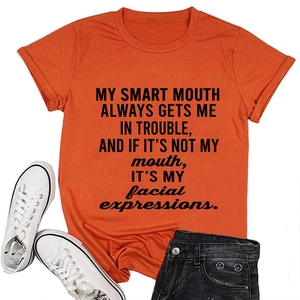 Detail view of orange cotton t-shirt featuring black slogan and crew neck design