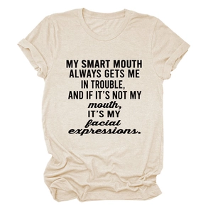 Detail of rolled cuffs and black slogan print on a cream crew neck cotton t-shirt