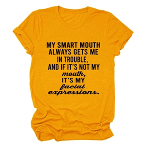 Close-up of printed slogan text and fabric texture on a bright orange crew neck T-shirt
