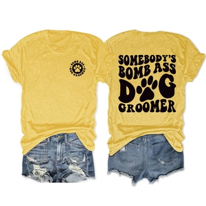 Flat lay of mustard yellow T-shirt with vintage dog groomer print and denim shorts