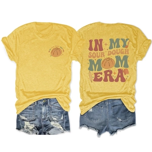 Detail of In My Sourdough Mom Era print on mustard t-shirt with denim shorts