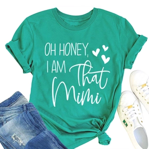 Flat lay of a green crew neck T-shirt featuring 'OH HONEY' slogan with denim jeans
