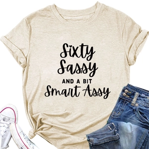 Flat lay of beige cotton T-shirt with Sixty Sassy print, denim shorts and sneakers