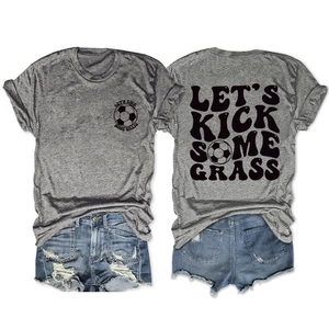 Dettaglio macro della stampa calcio 'LET'S KICK SOME GRASS' su t-shirt grigia in cotone