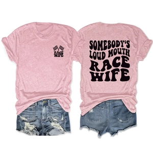 Flat lay of pink Race Wife graphic t-shirt and distressed denim shorts outfit set