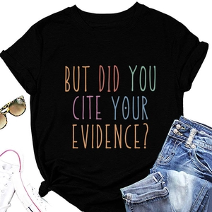 Flat lay van zwart T-shirt met kleurrijke tekst, knoopdetail en modeaccessoires