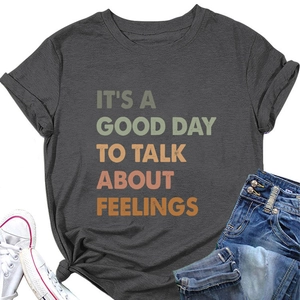 Close-up of 'It's a Good Day' slogan tee with a side knot detail and dark grey cotton fabric