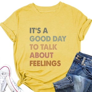 Close-up of yellow 'It's a good day to talk' graphic t-shirt with knotted detail