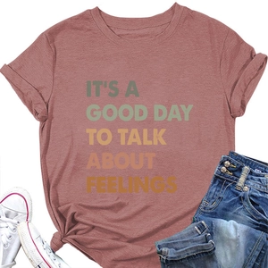 Detail of brick red cotton T-shirt with rolled sleeves, knot hem, and inspirational text