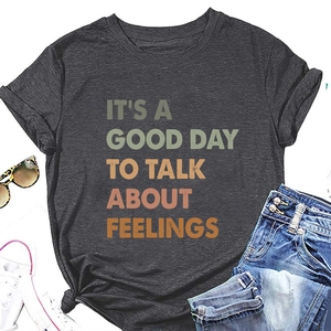 Flat lay of charcoal grey T-shirt with vintage 'It's a good day' print and accessories
