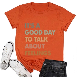 Flat lay of an orange cotton T-shirt with mental health slogan and black denim shorts