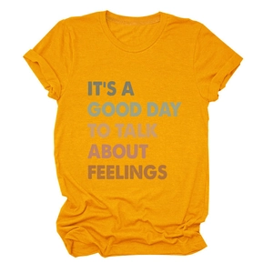 Detail of ginger yellow cotton T-shirt featuring colorful slogan and rolled sleeves