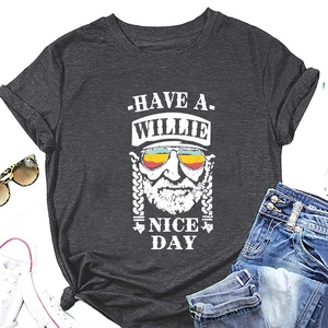 Flat lay of charcoal grey Willie print T-shirt styled with denim shorts and sunglasses