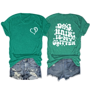 Flat lay of heather green t-shirt with Dog Hair Is My Glitter back print and front heart logo
