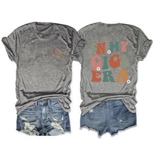Flat lay of gray In My Gigi Era t-shirt and ripped denim shorts summer two-piece outfit