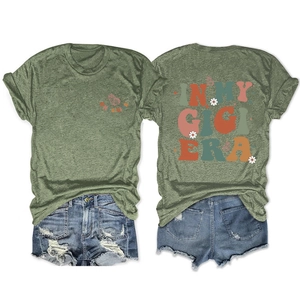 Close-up of 'IN MY GIGI ERA' colorful retro print and daisy pattern on army green t-shirt
