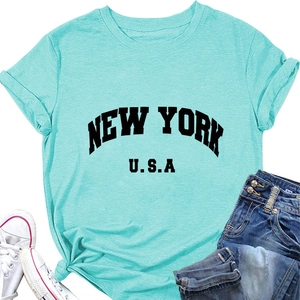 Détail du t-shirt vert menthe New York U.S.A. avec manches retroussées et nœud à l'ourlet