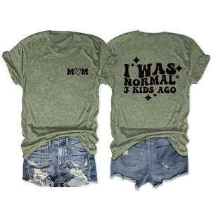 Front and back view of green T-shirt with I WAS NORMAL 3 KIDS AGO print and denim shorts