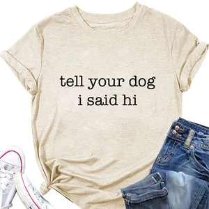 Flat lay of an oat-colored T-shirt with 'tell your dog i said hi' text and denim jeans