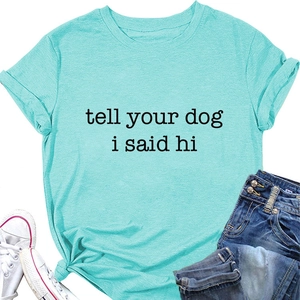 Flat lay of light blue T-shirt with 'tell your dog i said hi' slogan and rolled sleeves