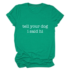 Detail of green T-shirt with white 'tell your dog i said hi' slogan and rolled sleeves